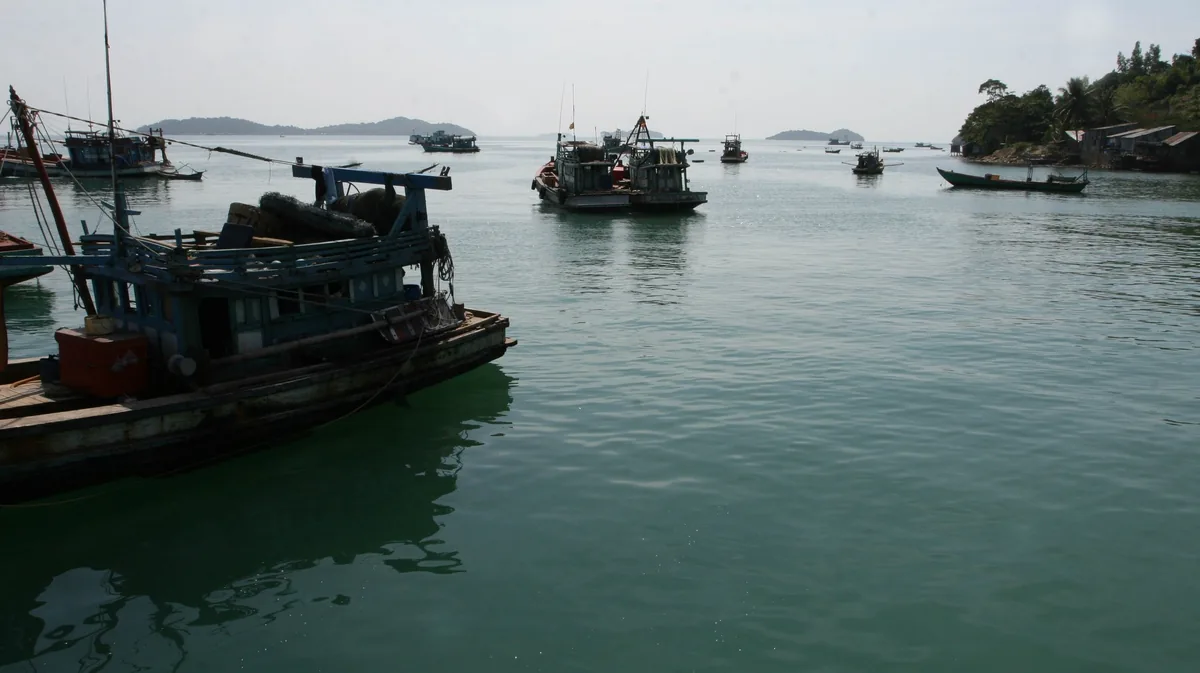 Những chiếc thuyền đánh cá bằng gỗ đậu trên vùng nước xanh êm ả gần bờ biển Hà Tiên.