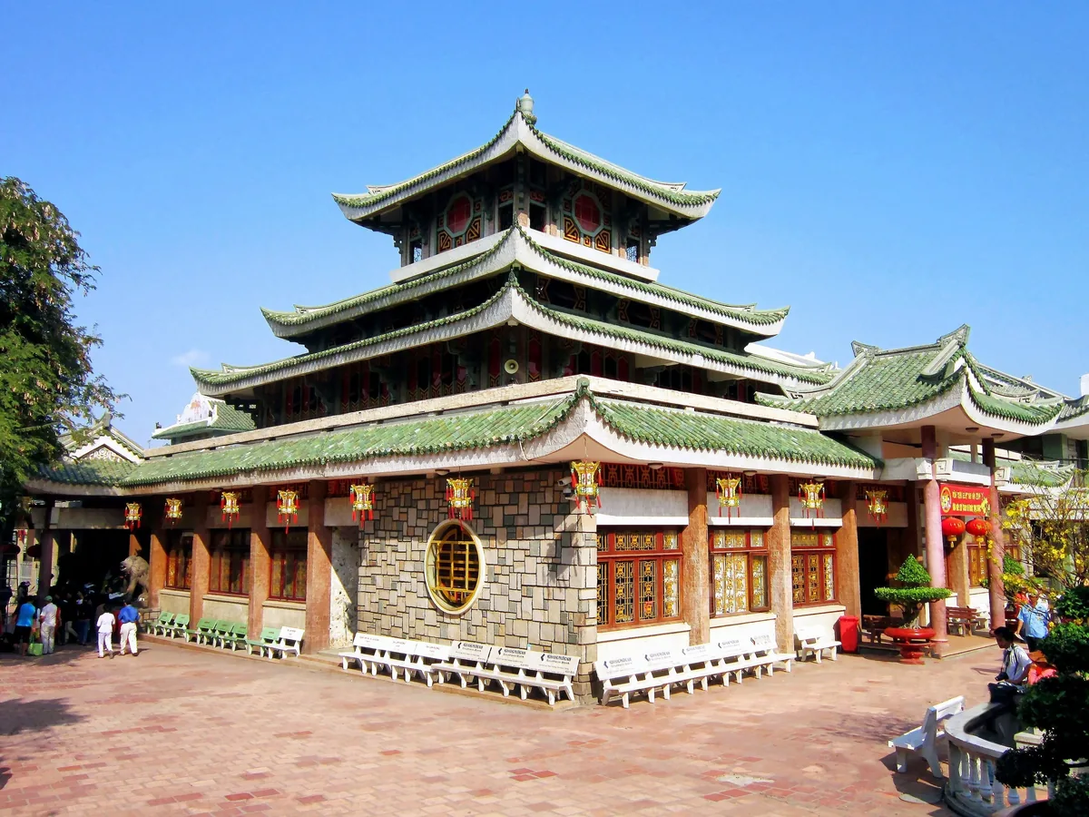 Mái chùa nhiều tầng lợp ngói xanh cùng đèn lồng đỏ tại Miếu Bà Chúa Xứ Núi Sam, Châu Đốc.