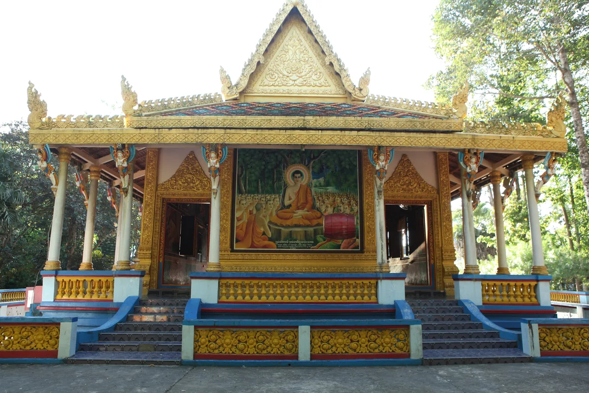 Một ngôi chánh điện chùa Khmer viền vàng với tranh tượng Phật nằm giữa cây xanh ở Sóc Trăng.