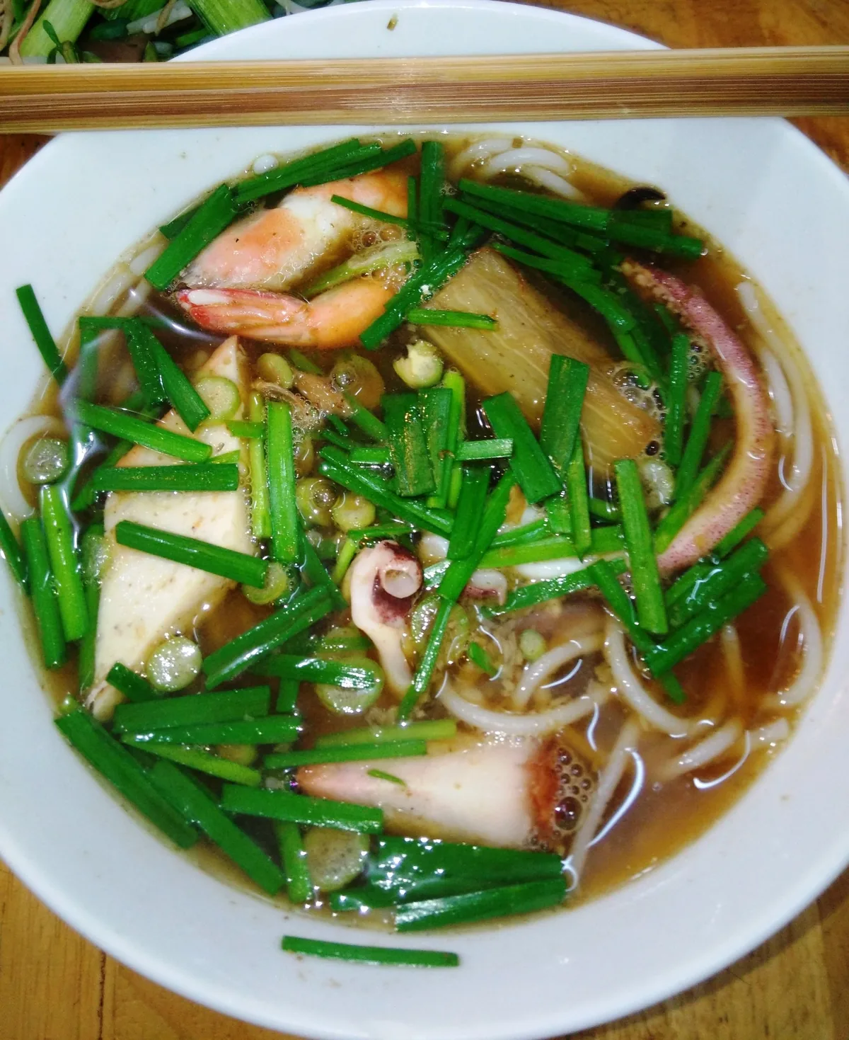 Một tô bún mắm hải sản Bạc Liêu với tôm, mực, đậu hũ và hẹ tươi.
