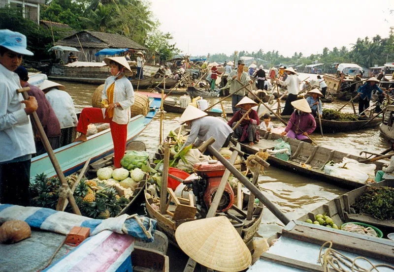Những chiếc thuyền chở đầy trái cây và rau củ chen chúc tại chợ nổi tấp nập ở đồng bằng sông Cửu Long